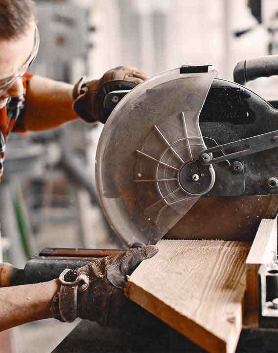 Wood cutting with circular saw. Closeup of mature man sawing lumber